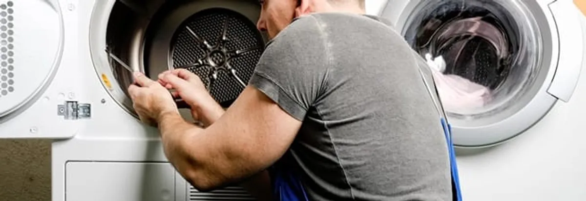 Dryer repair technician fixing a clothes dryer drum in Arlington, TX