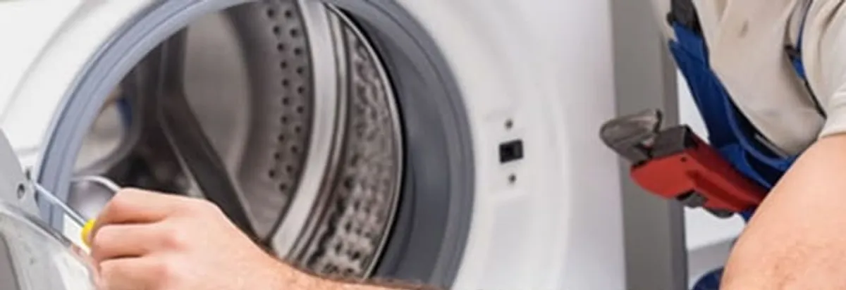 Appliance technician repairing a clothes dryer drum and internal parts in Arlington, TX