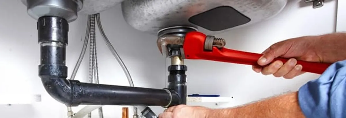 Garbage disposal repair technician tightening the sink drain and disposal connection in Arlington, TX