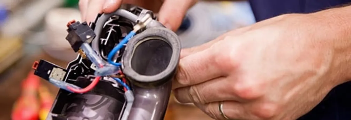 Vacuum repair technician reconnecting wiring and components in Arlington, TX