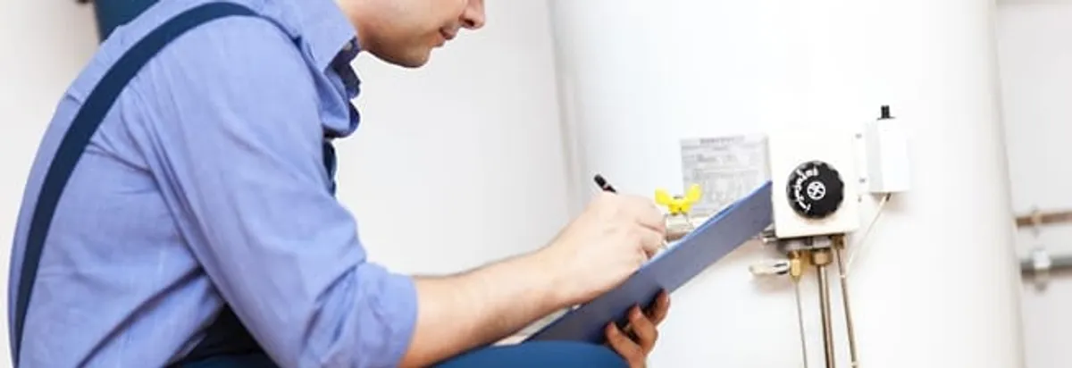Water heater repair technician inspecting the unit and recording service notes in Arlington, TX