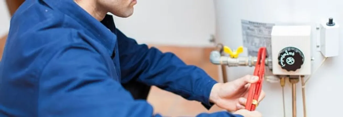 Water heater repair technician adjusting the temperature control and gas valve in Arlington, TX